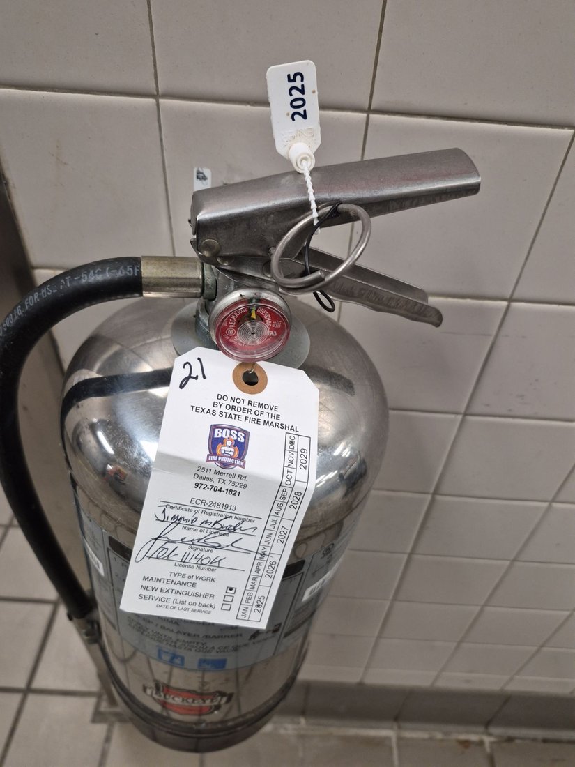 A Class K commercial fire extinguisher inspected and tagged by Boss Fire Protection at a school kitchen in Granbury, TX