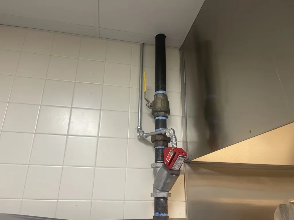Boss Fire Protection tying in the gas shutoff valve and detection line on a commercial kitchen fire suppression system in Dallas-Fort Worth, TX