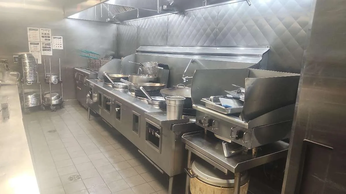 Commercial kitchen hood with wet chemical fire suppression nozzles positioned for full appliance coverage, installed by Boss Fire Protection in Dallas-Fort Worth, TX
