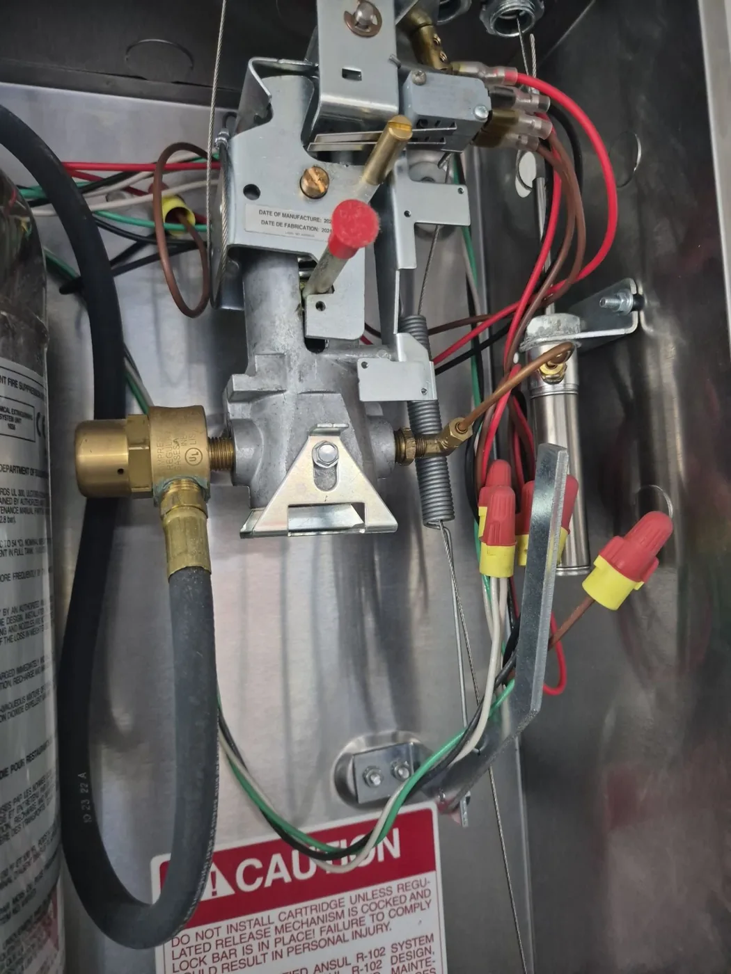 Close-up of an ANSUL R-102 fire suppression control head and regulated release assembly serviced by Boss Fire Protection in Arlington, TX