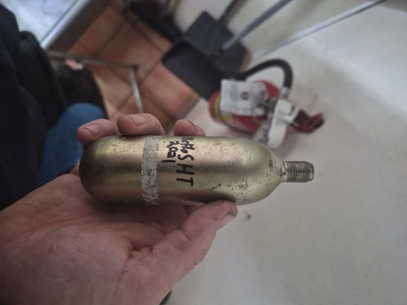 Boss Fire Protection technician holding a replacement Kidde fire suppression system cartridge during a red-tag repair in Fort Worth, TX