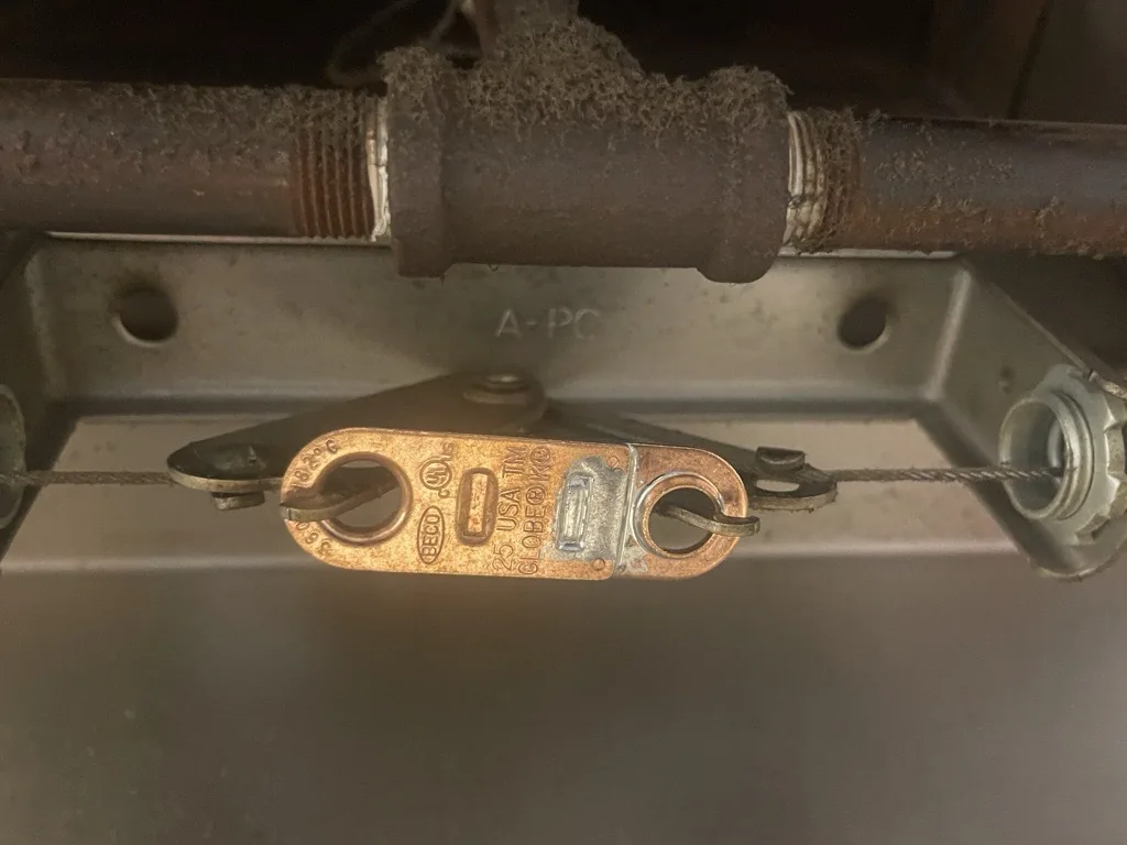 A fusible link on a commercial kitchen fire suppression detection line, checked by Boss Fire Protection in Prosper, TX