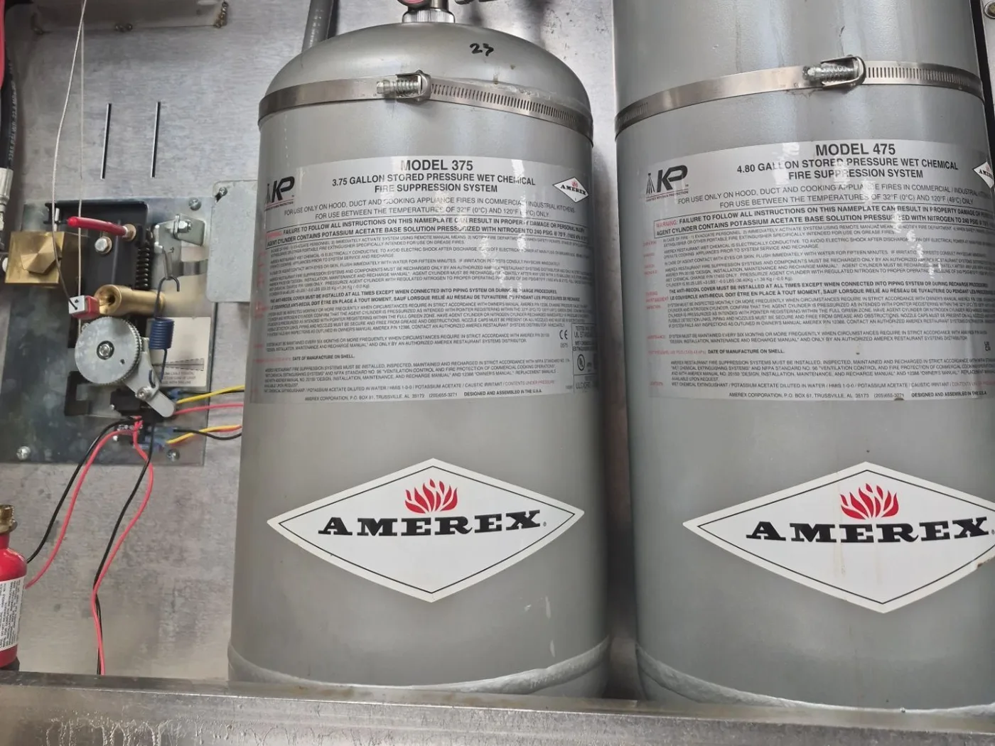 Two Amerex KP wet chemical fire suppression cylinders (Model 375 and 475) with the control head and gas valve on a Boss Fire Protection inspection at a commercial kitchen in Plano, Dallas-Fort Worth, TX